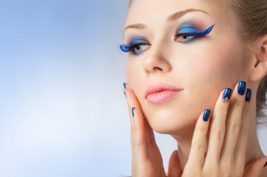 A woman with blue makeup and blue nails