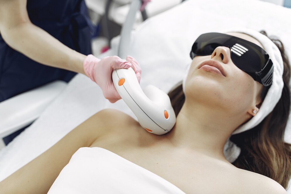 A lady is laying on the bed for laser treatment in a laser hair removal treatment